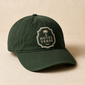 Boutique hotel cap in forest green with cream embroidered crest
